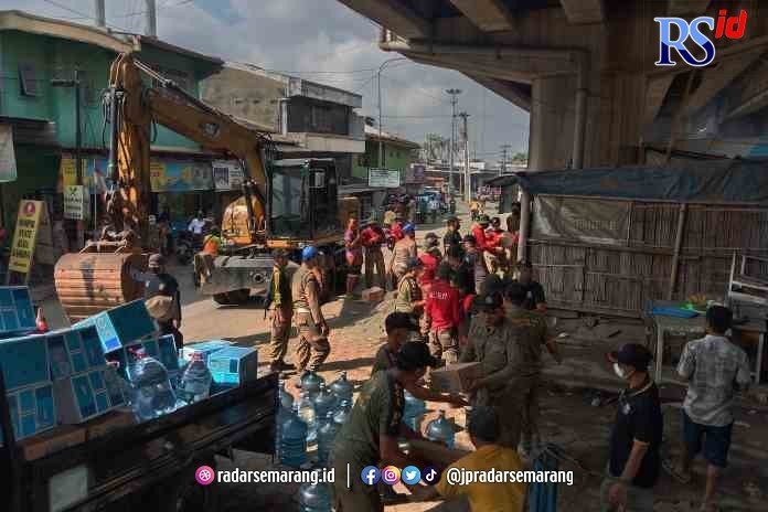DIBERSIHKAN: Petugas Satpol PP Kota Semarang membongkar 30 lapak PKL di bawah fly over Tanjung Emas, Semarang, kemarin. Lahan ini rencananya akan dibangun ruang terbuka hijau (RTH). (NUR CHAMIM/RADARSEMARANG.COM)