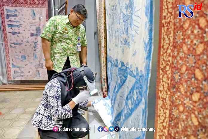 RAWAT KOLEKSI: Petugas dari Museum Batik Pekalongan saat memeriksa koleksi batik kelengan. (Istimewa)