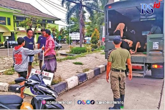 BANTU PENGUNGSI: Tim Satpol P3KP Kota Pekalongan membantu warga yang mengungsi pulang ke rumah masing-masing. (Luthfi Hanafi/RADARSEMARANG.COM)